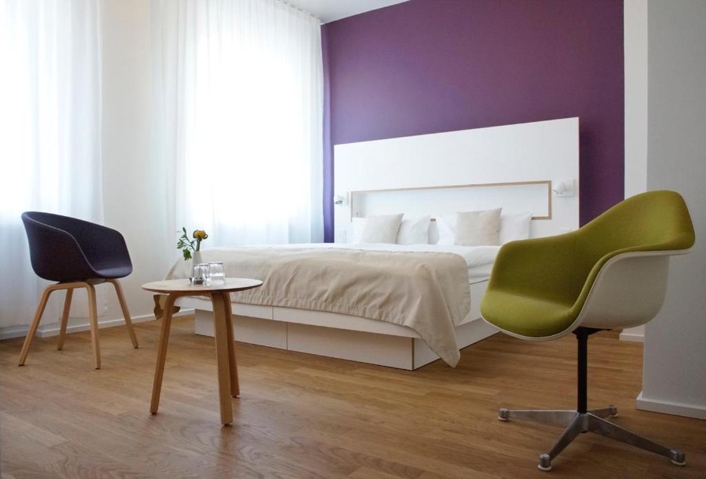 a bedroom with a bed and a chair and a table at ART Hotel Ufer in Düsseldorf