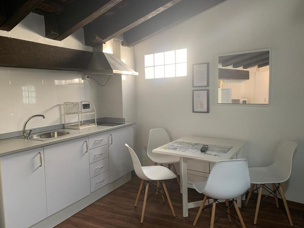 a kitchen with white cabinets and a table and chairs at Down Town in Valencia