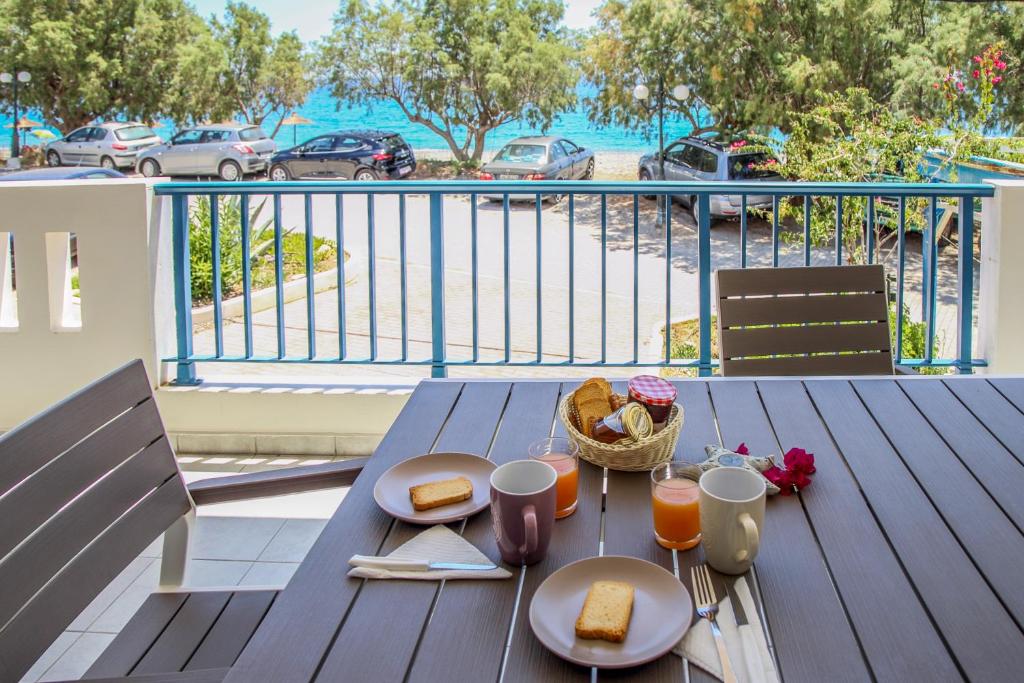 a table with a basket of bread and drinks on a balcony at MMM Apartment in Makry Gialos