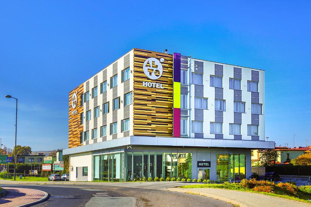 a hotel building with a sign on the front of it at Hotel Alto Żory in Żory