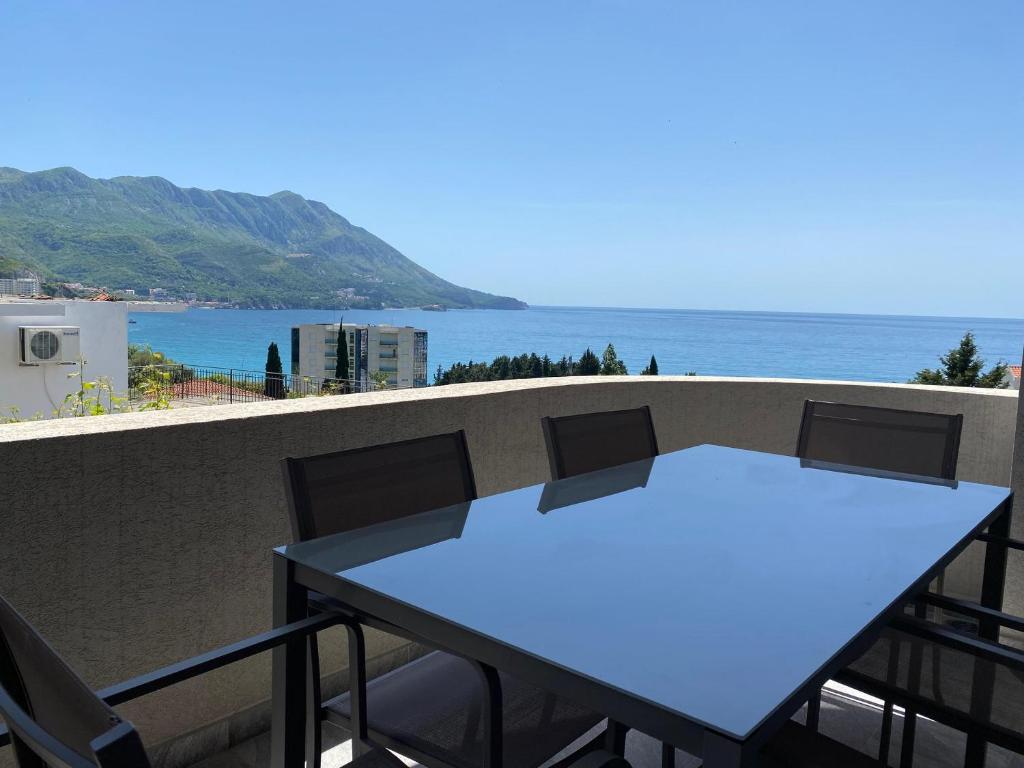 una mesa azul y sillas en un balcón con vistas al océano en B&T Apartments, en Budva