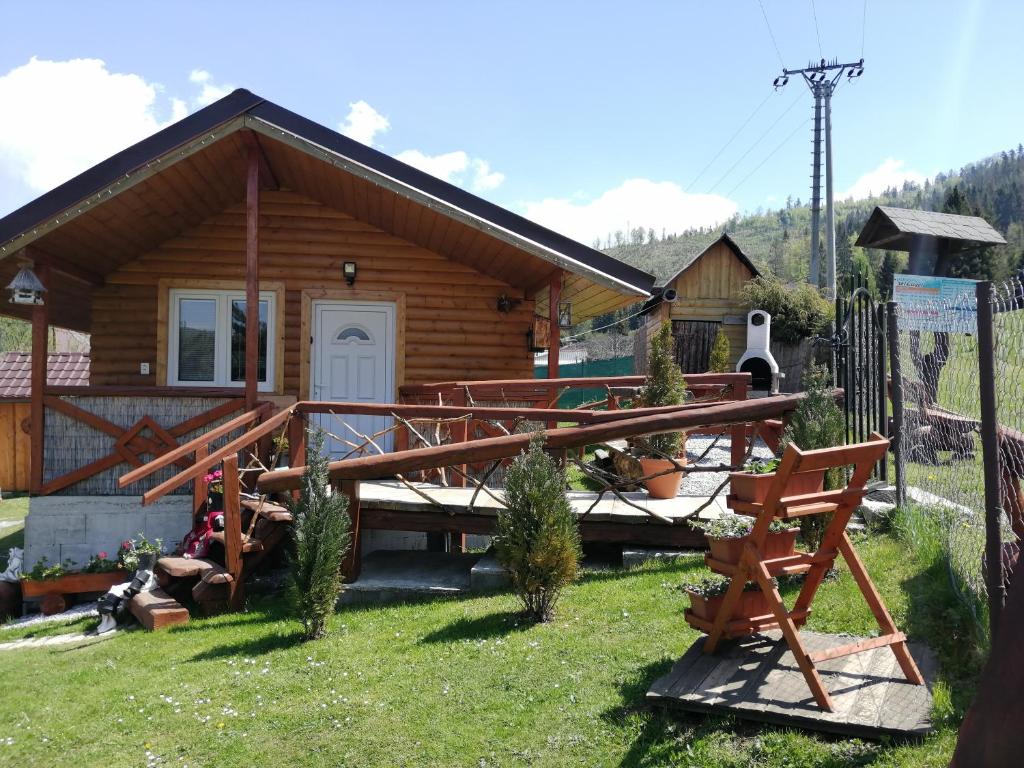 a log cabin with a deck and a house at Ubytovanie Lesky in Mlynky 
