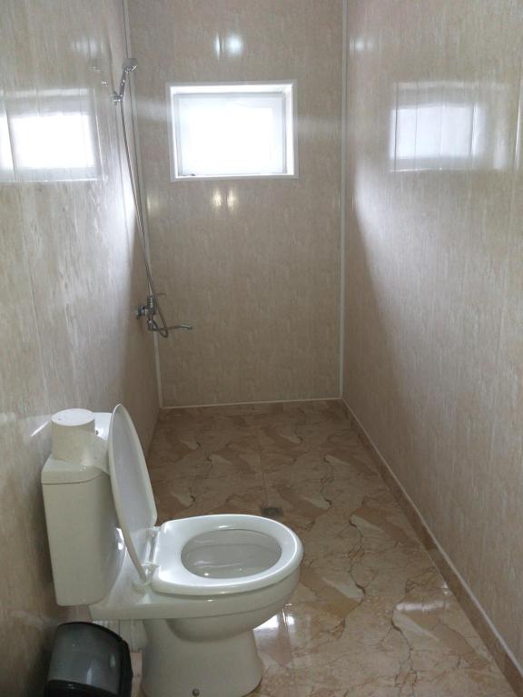 a bathroom with a toilet and a marble floor at Guesthouse Miranda in Ushguli