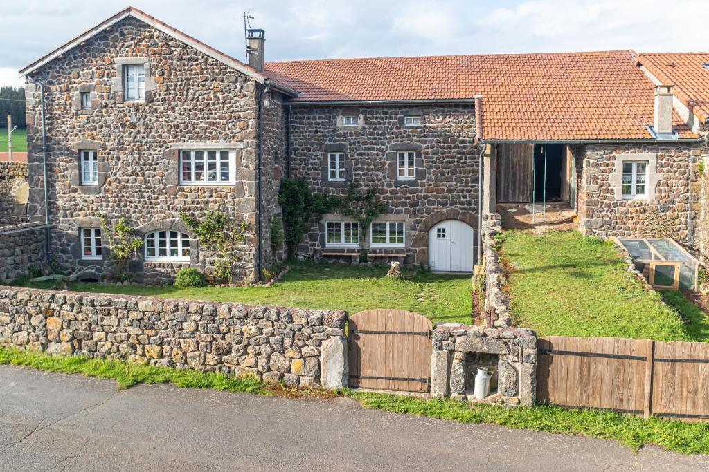 une ancienne maison en pierre avec un mur en pierre dans l'établissement Le Flambeau, à Le Bouchet-Saint-Nicolas