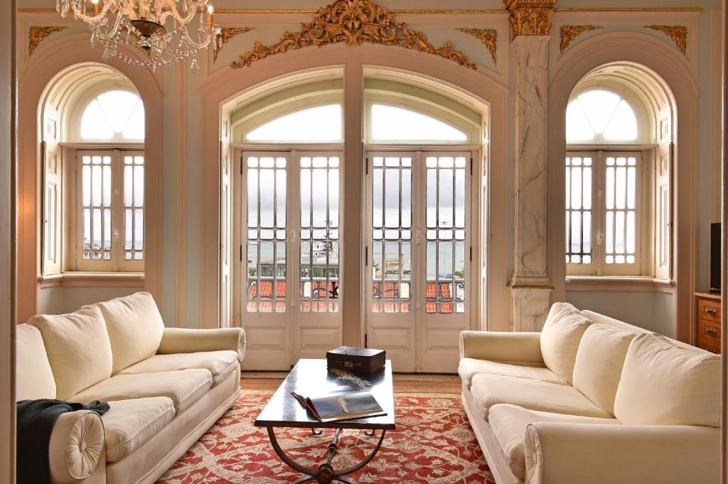 una sala de estar con 2 sofás blancos y una mesa. en Palacete Chafariz Del Rei - by Unlock Hotels en Lisboa