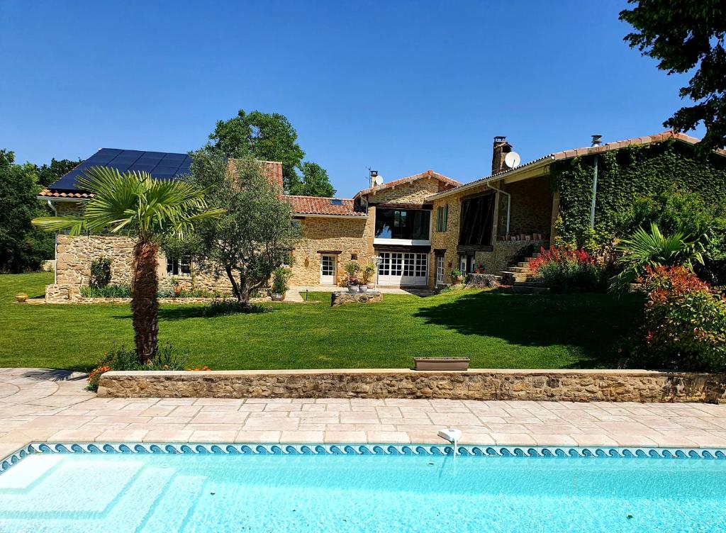 una casa con piscina frente a una casa en L'Ermitage de Saint-Bardoux en Saint-Bardoux