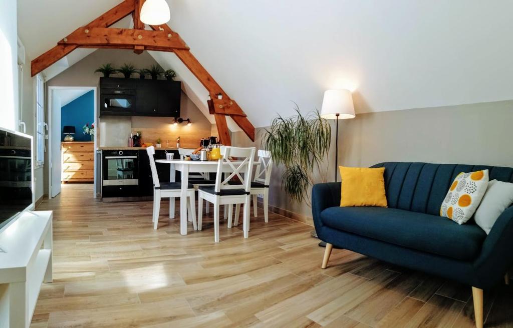 - un salon avec un canapé bleu et une table dans l'établissement Le petit Mérinos - Rambouillet -, à Rambouillet