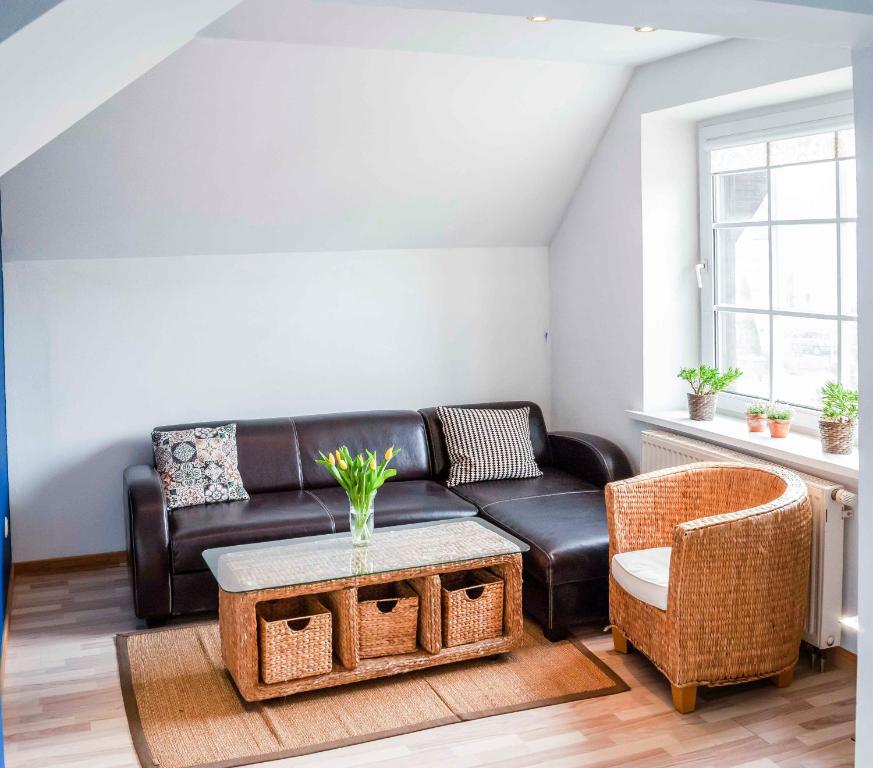 a living room with a leather couch and a table at Cinnamon villa in Palanga