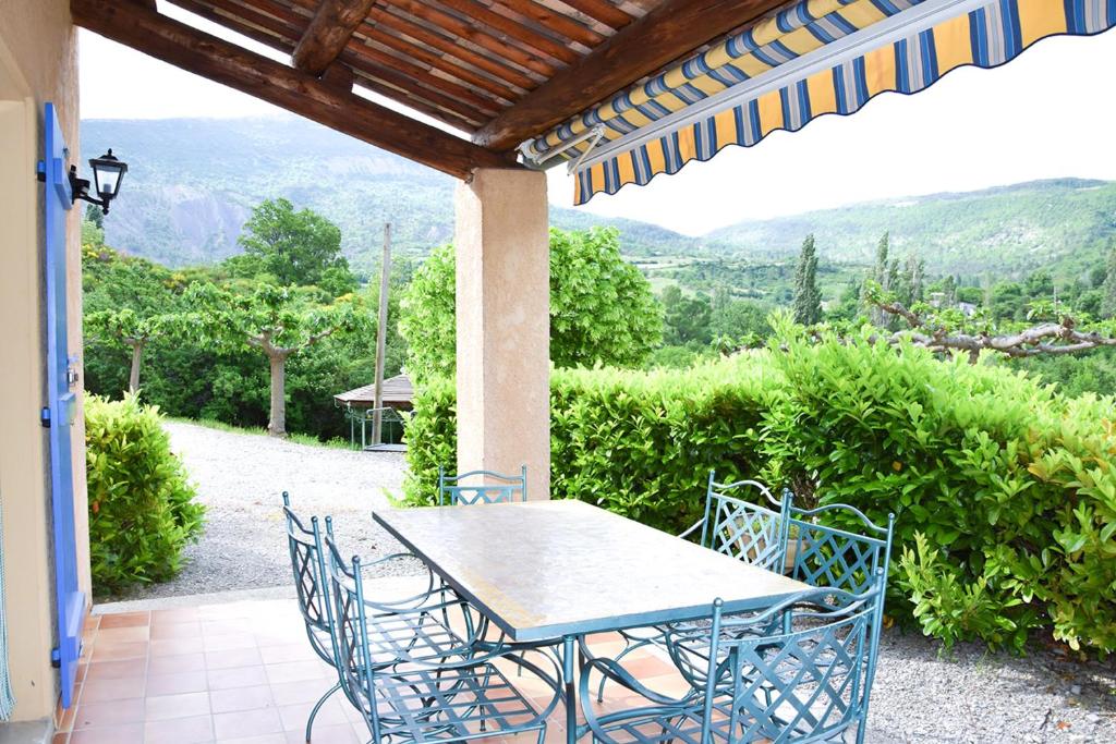 une table et des chaises sur une terrasse avec vue dans l'établissement Appartement confortable à La Roche, 90 m² avec piscine partagée !, à La Roche-sur-le-Buis