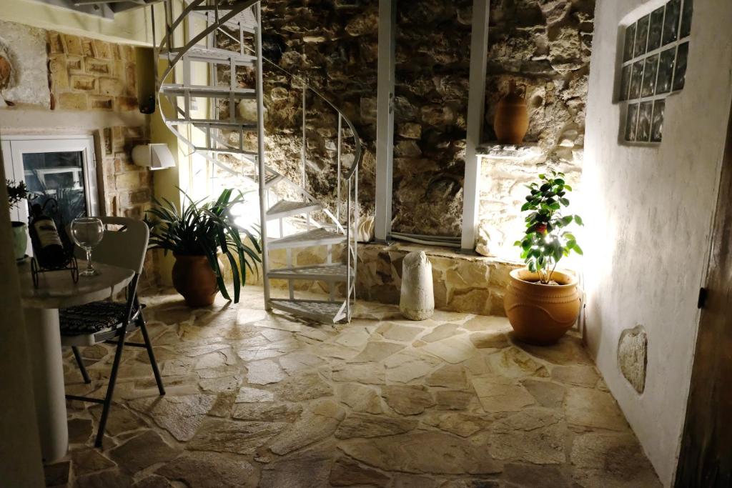 a stone room with a table and potted plants at George Studio in Athens