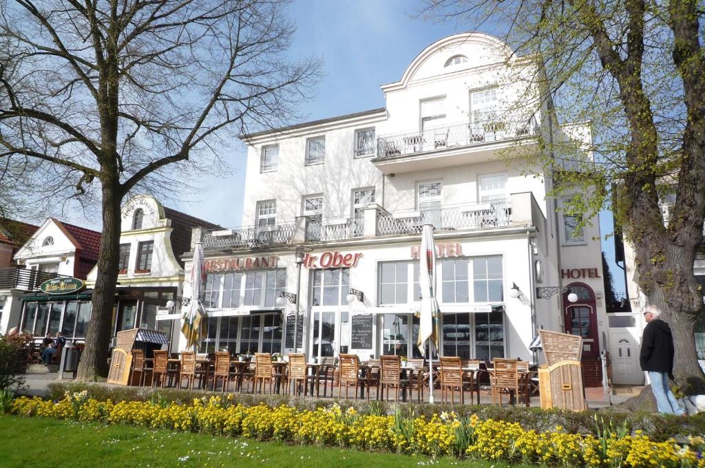 a white building with chairs in front of it at Doppelzimmer Menue, direkt am Alten Strom in Warnemünde