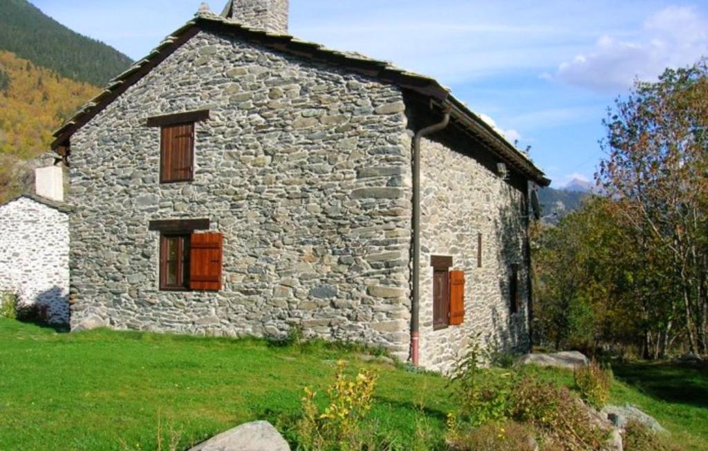 an old stone house in a field of grass at Chalet de 3 chambres avec jardin amenage et wifi a Saint Andre a 8 km des pistes in Saint-André