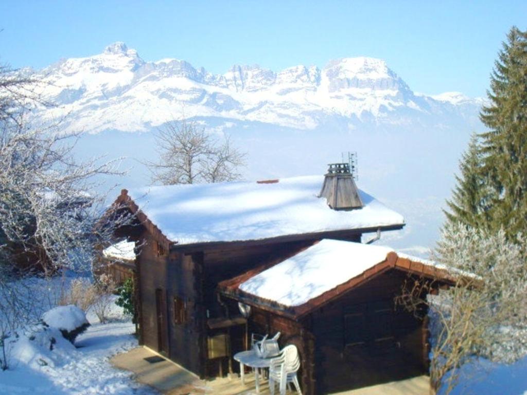 Cabaña pequeña con una montaña cubierta de nieve en el fondo en Chalet de 2 chambres avec terrasse amenagee et wifi a Saint Gervais les Bains a 3 km des pistes en Saint-Gervais-les-Bains