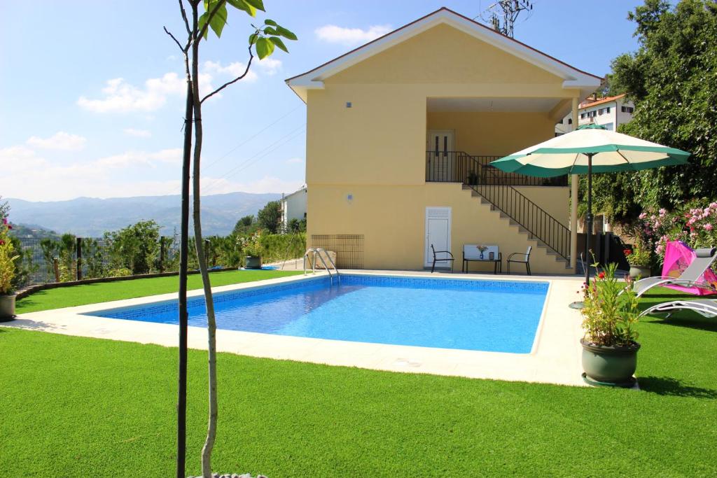 een zwembad in de tuin van een huis bij 3 bedrooms villa with private pool furnished garden and wifi at Sao Martinho de Mouros 1 km away from the beach in Frende