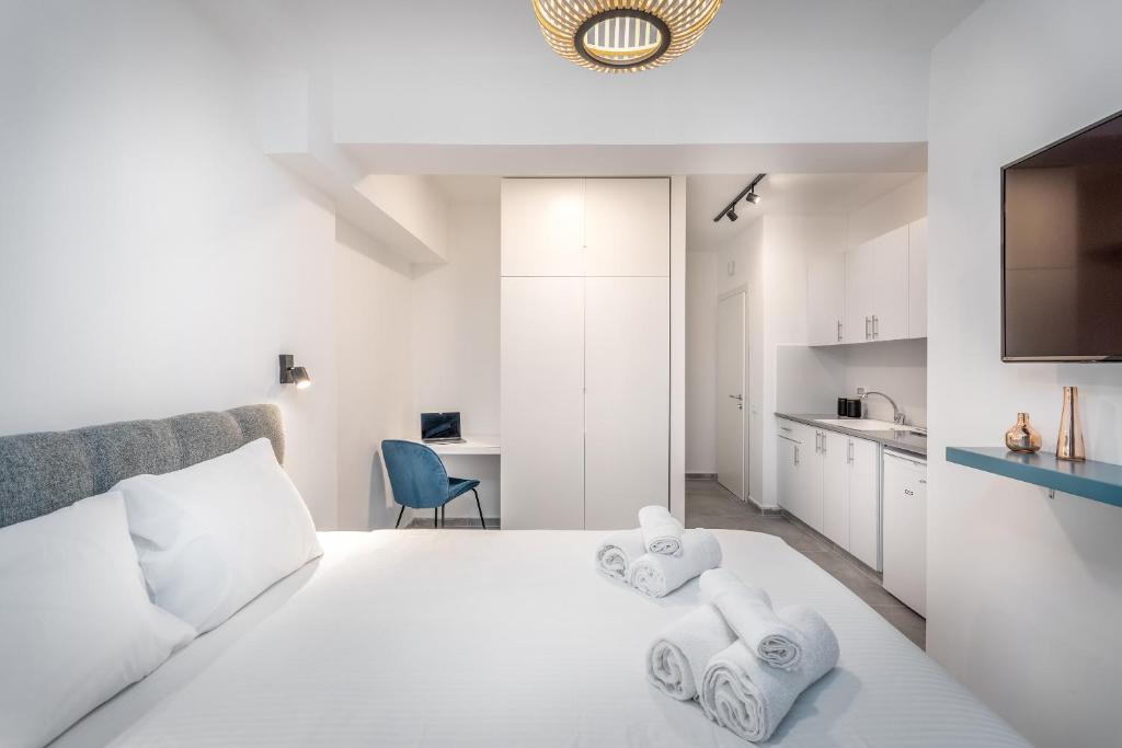 - une chambre avec un lit blanc et des serviettes dans l'établissement GORDON APPART HOTELs, à Tel Aviv