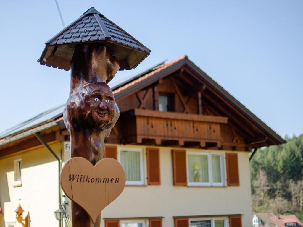a statue of a bear holding a heart in front of a house at Haus Harter in Wolfach