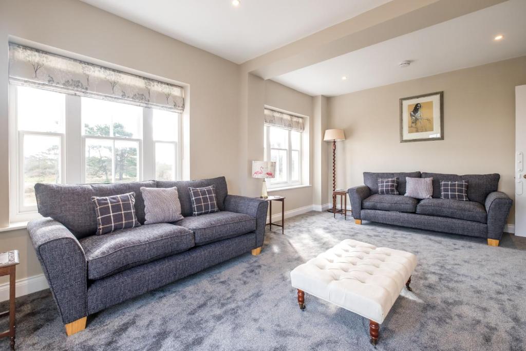 a living room with two couches and a stool at The Dower House in Sizewell