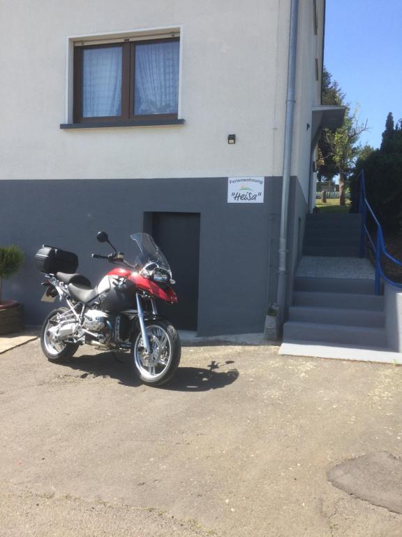 une moto garée devant un bâtiment dans l'établissement HeiSa, à Bitzen