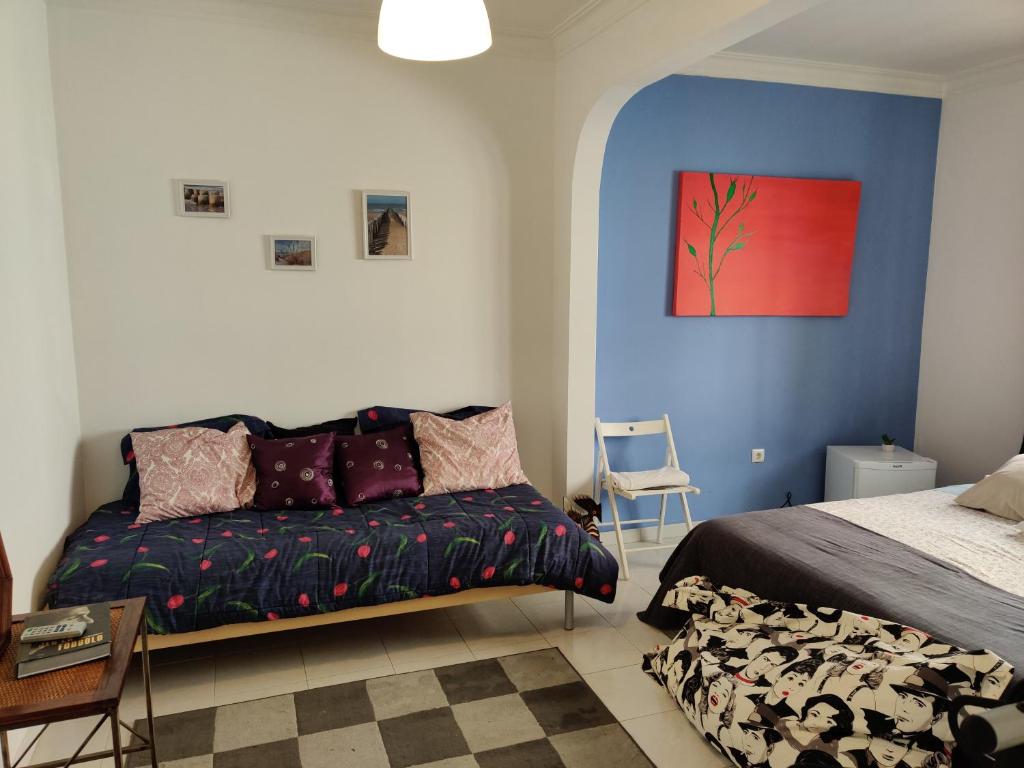 a bedroom with a bed and a couch in it at Vasco Santana Guesthouse in Odivelas