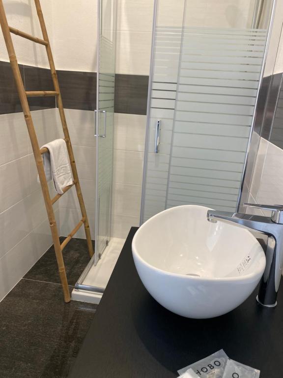 La salle de bains est pourvue d'un lavabo et d'une douche en verre. dans l'établissement Hall inn B&B in Chiostro, à Naples