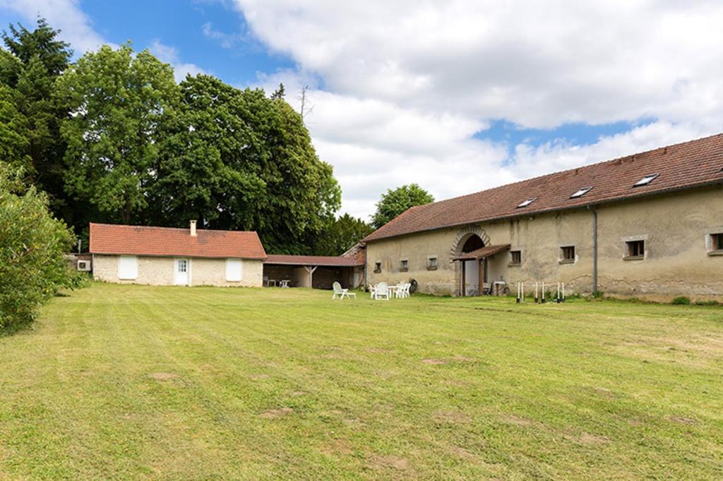 a large building with two white chairs in a field at Maison de 4 chambres avec jardin amenage et wifi a Monthenault in Monthenault