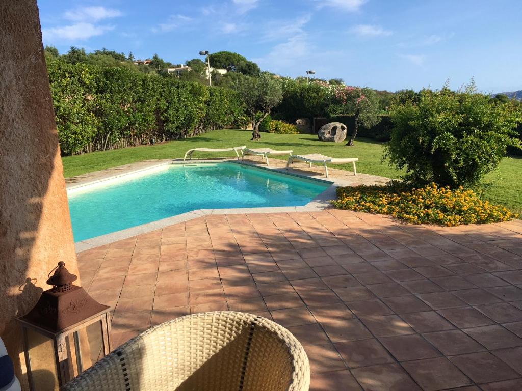a swimming pool in a yard with a table and chairs at 4 bedrooms villa at Palau 600 m away from the beach with sea view private pool and enclosed garden in Palau