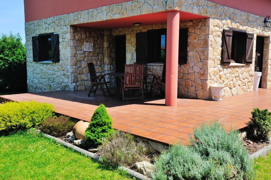 a patio with a wooden deck in front of a stone building at Charming house in Albuerne with fenced garden in Albuerne