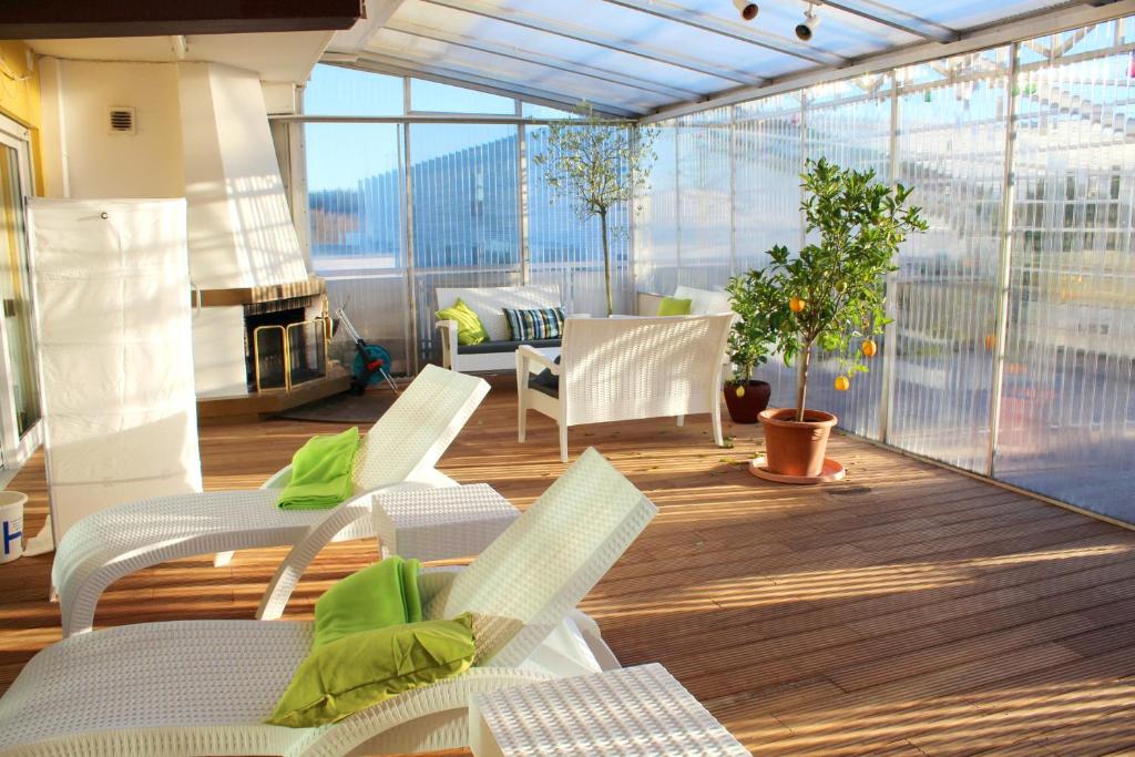 uma varanda com cadeiras e uma lareira num edifício em 2 bedrooms appartement with indoor pool enclosed garden and wifi at Sauerlach em Sauerlach
