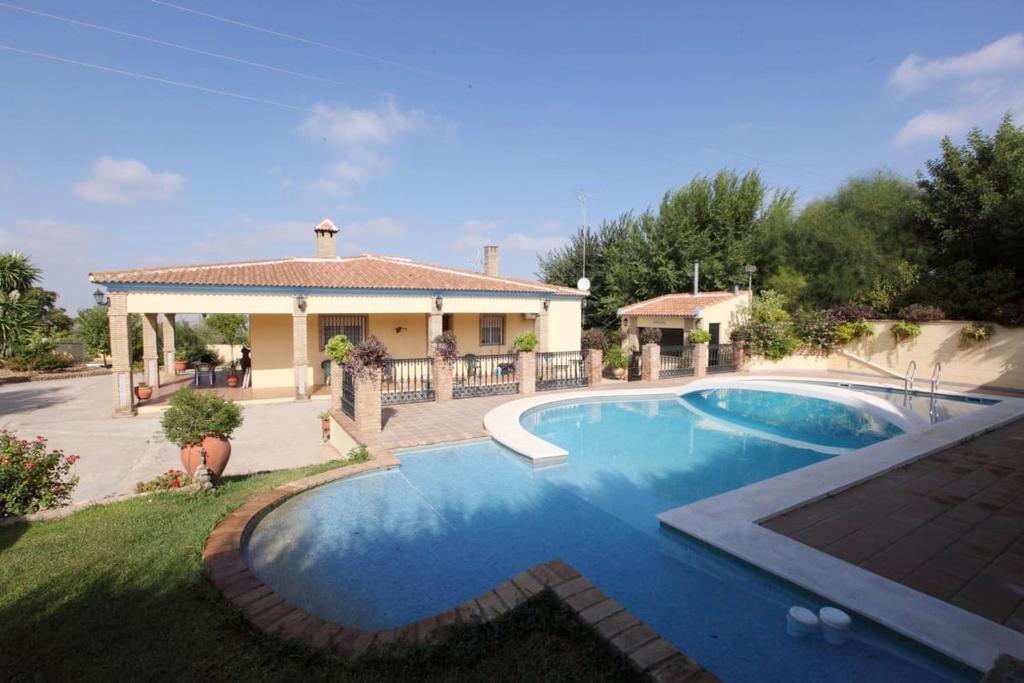 una casa con piscina en el patio en 4 bedrooms villa with private pool enclosed garden and wifi at Sanlucar la Mayor, en Sanlúcar la Mayor