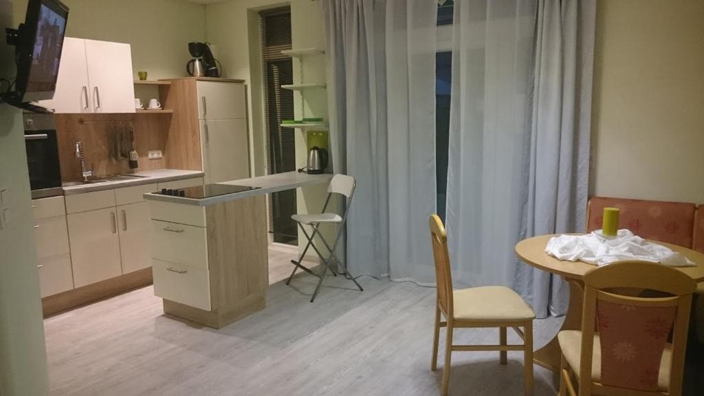 uma cozinha com uma mesa e uma pequena mesa e cadeiras em ApartmentHotel Vollumen em Redwitz an der Rodach