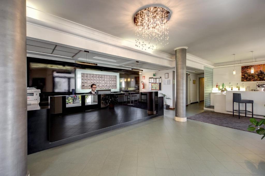 a woman is standing in a lobby with a presentation at Hotel Alba Roma in Rome