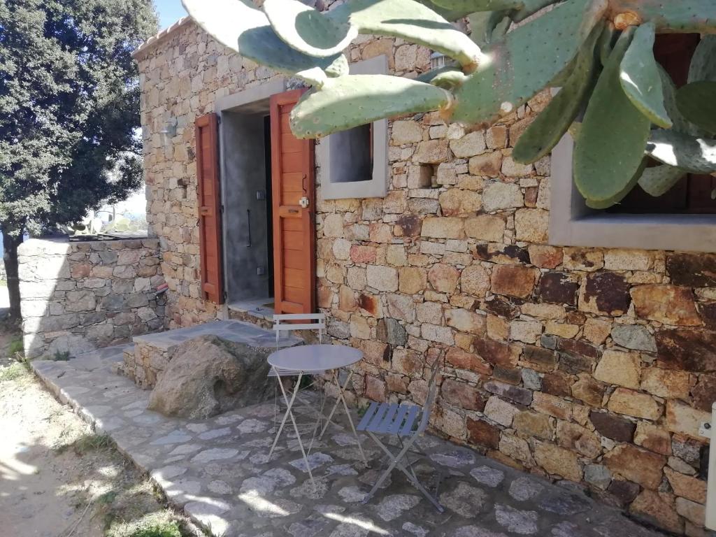 een stenen huis met een tafel en stoelen ervoor bij Clos Olivella in Monticello