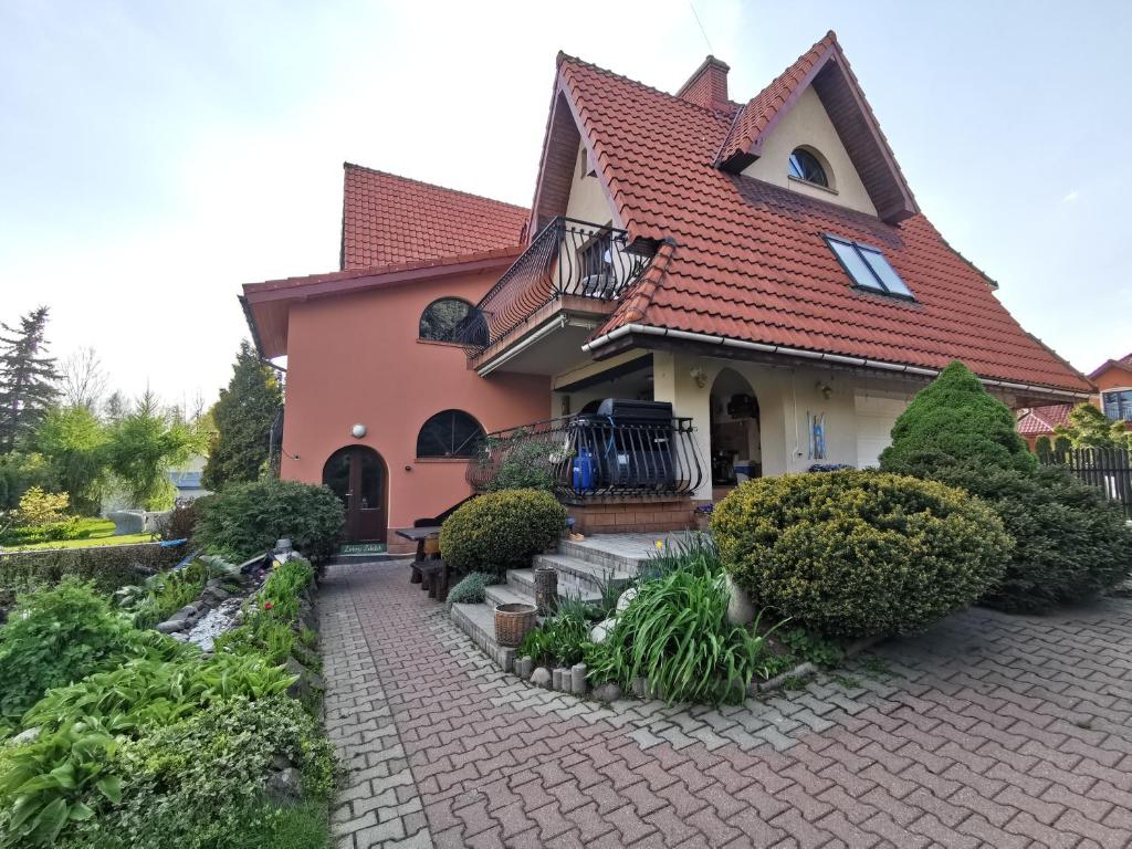 uma casa com um telhado vermelho e uma entrada de tijolos em zielony zakątek em Nowy Targ