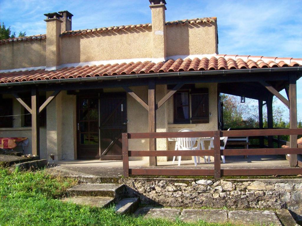 una casa con un porche con un banco en la parte delantera en Maison d'une chambre avec vue sur la ville jardin amenage et wifi a Puy l'Eveque, en Puy-lʼÉvêque