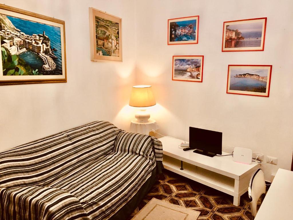 Schlafzimmer mit einem Bett und einem Schreibtisch mit einem Computer in der Unterkunft Appartamento Andromeda in Vernazza