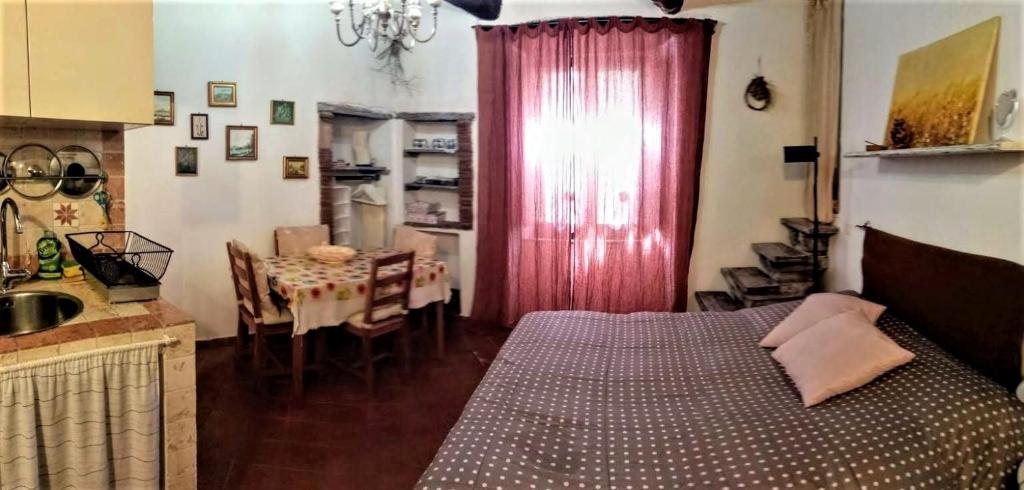 una camera con letto e una cucina con tavolo di Tufoletto a Pitigliano