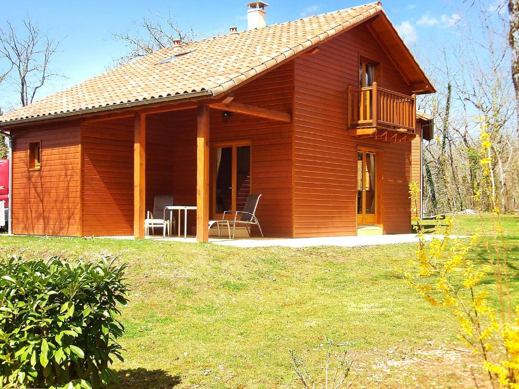 a small wooden house with a porch and a deck at Maison de 2 chambres avec vue sur le lac piscine partagee et jardin amenage a Lachapelle Auzac in Lachapelle-Auzac