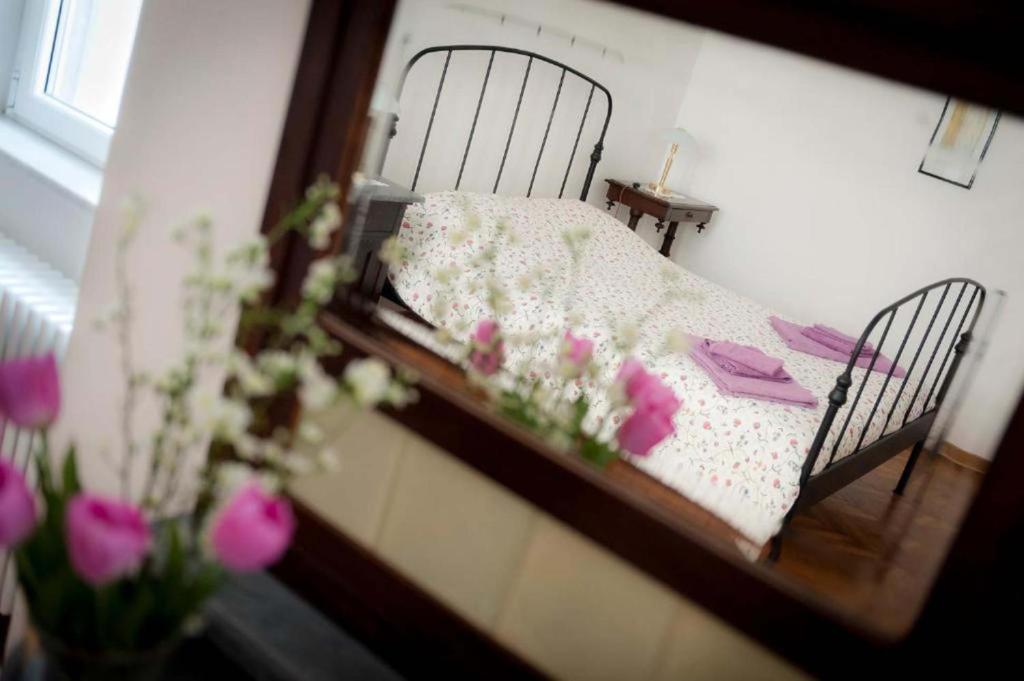 a reflection of a bed in a mirror with pink flowers at Domus Liberta - Boutique Rooms in Trieste