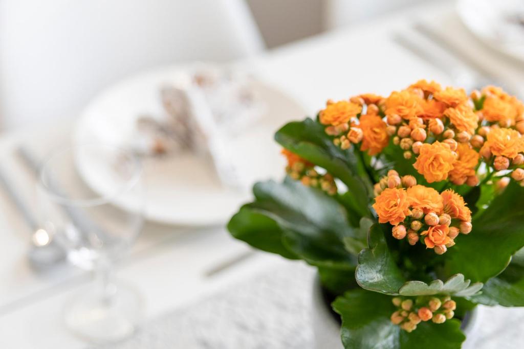 a vase filled with orange flowers on a table at Tuomas´ luxurious suites, Kelo in Rovaniemi