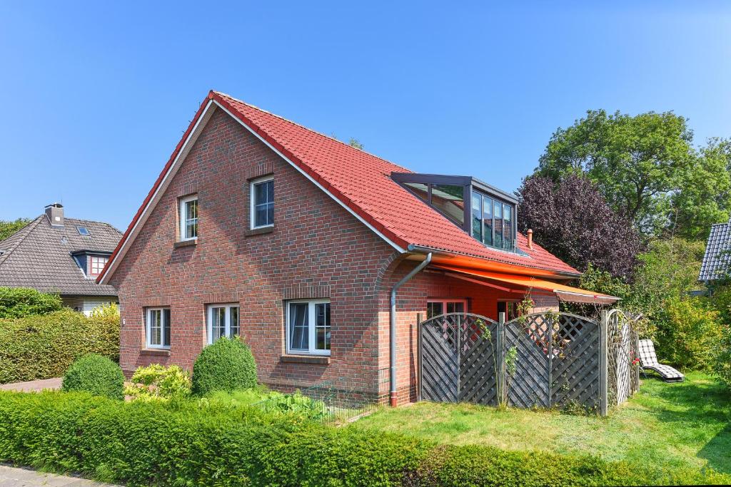 une maison en briques rouges avec un toit rouge dans l'établissement Jever-Ferienhaus Himmelsblick, à Jever