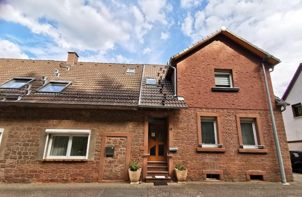 a red brick house with a brown door and windows at Ferienwohnung Am Salzbach in Lemberg