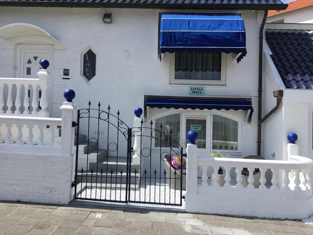 a white house with a white picket fence at little ibiza in Zandvoort