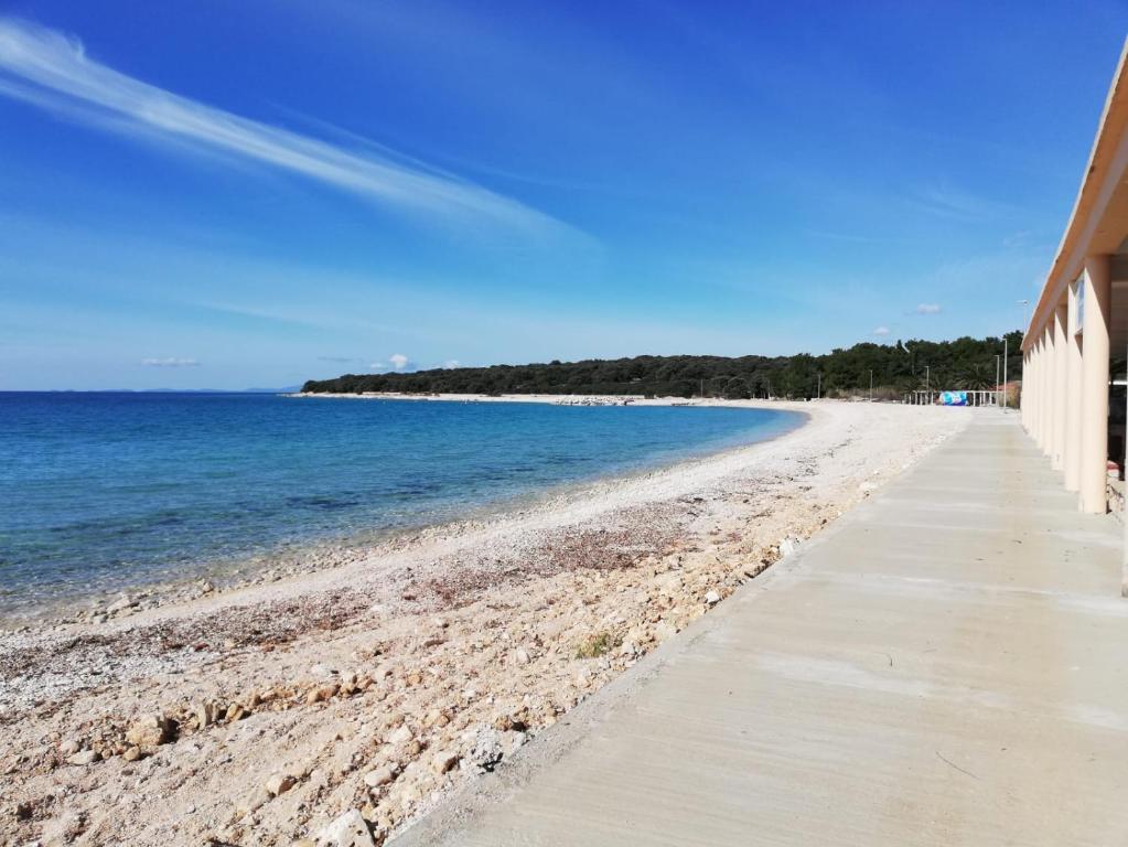 een zandstrand met een gebouw en de oceaan bij Apartment Tena in Novalja