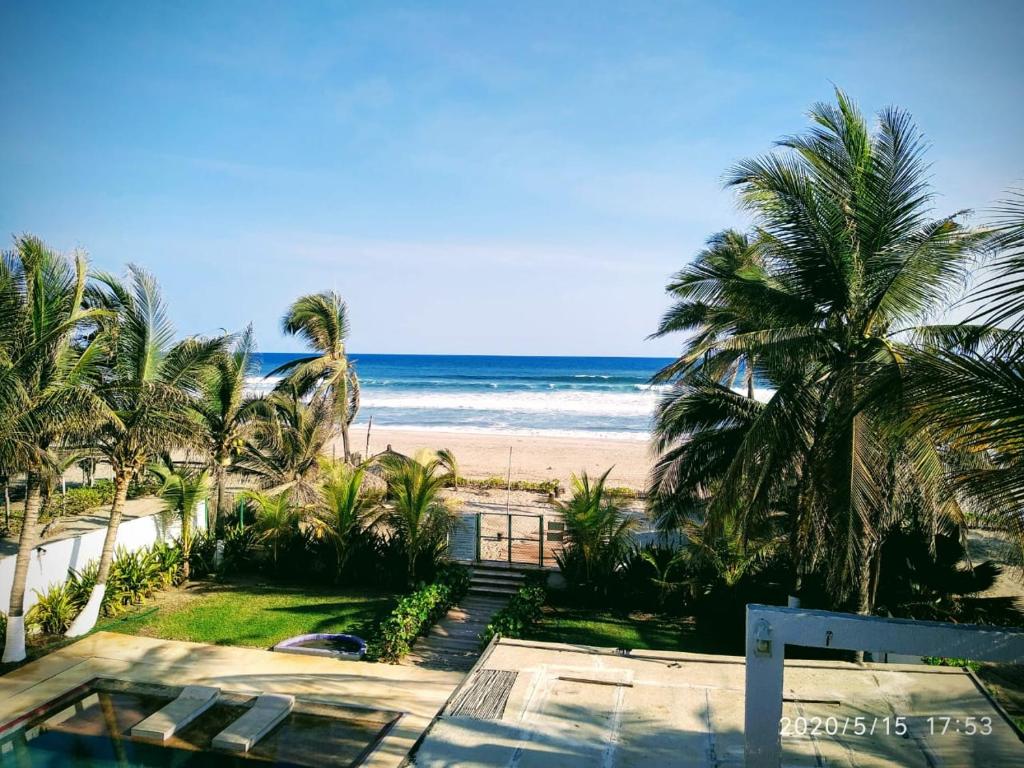 een uitzicht op een strand met palmbomen en de oceaan bij Quinta DIAMANTE Hotel in Barra Vieja