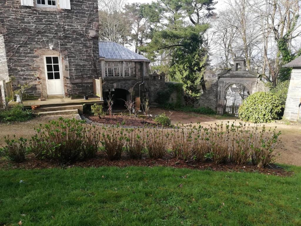 an old stone house with a garden in front of it at Chambres d&#39;hôtes Manoir Ker-Huella in Morlaix