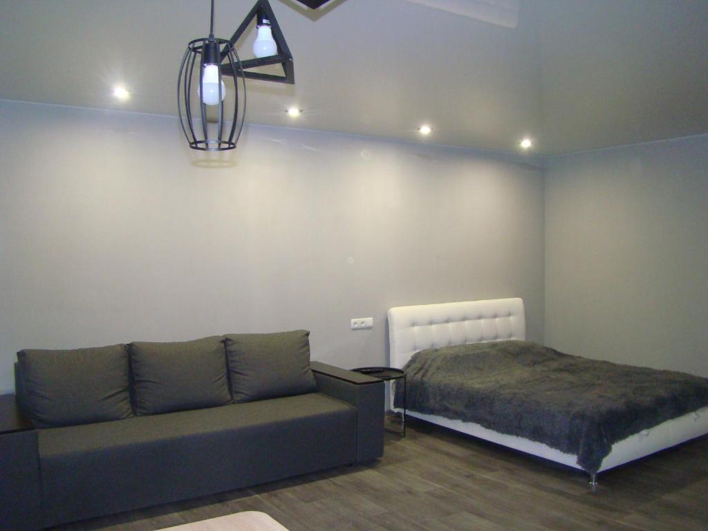 uma sala de estar com um sofá e uma cama em Квартира студия в центре Чернигова wi-fi em Chernihiv