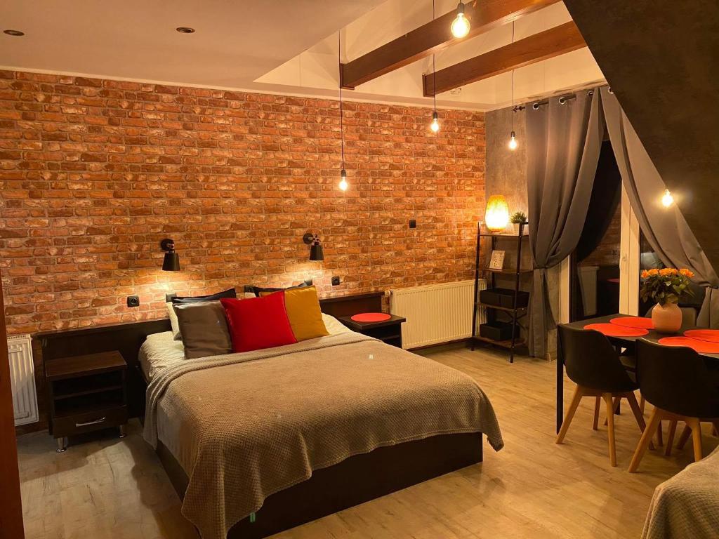 a bedroom with a bed and a brick wall at Pokoje Alicja in Łeba
