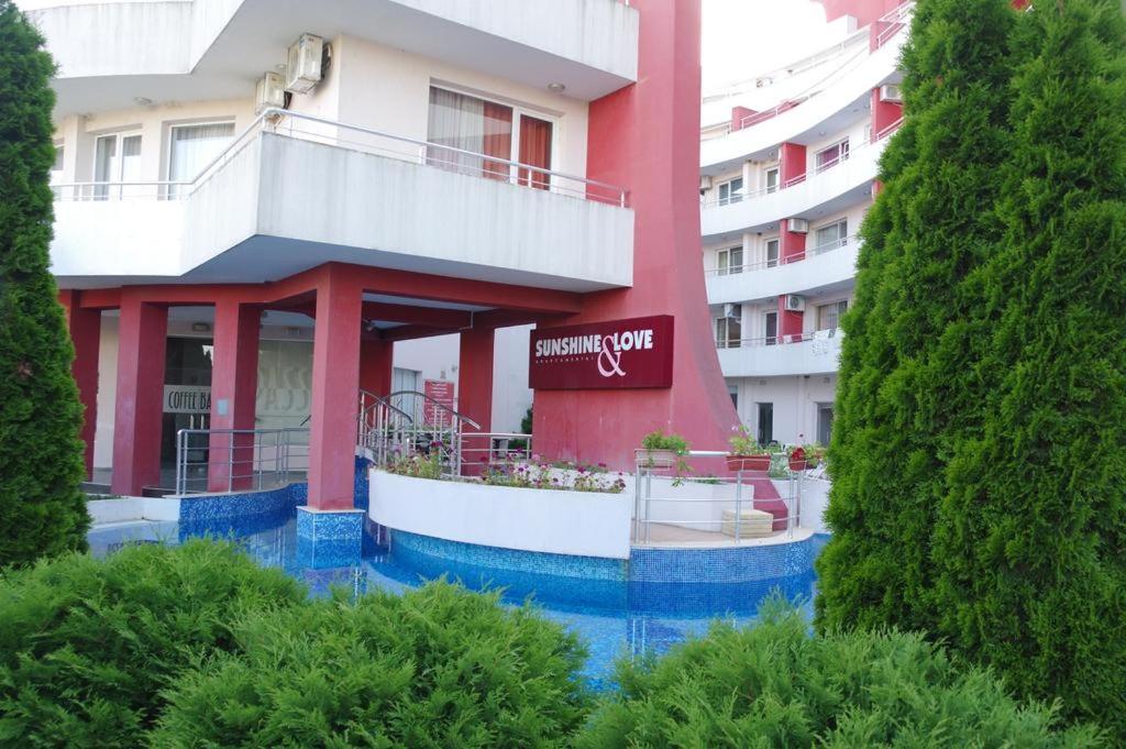 een rood-wit gebouw met een bord erop bij Apartments Victoria in Kranevo