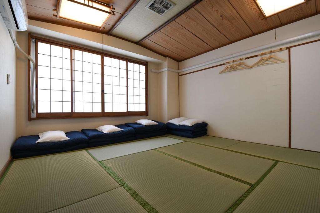 une chambre avec des canapés dans une pièce avec des fenêtres dans l'établissement Onsen Inn Hamayu Nagi / Vacation STAY 81903, à Beppu