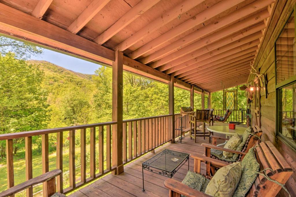 un porche cubierto con bancos y mesas en una cubierta en Enchanting Cabin with Mother-In-Law Suite Mtn Views, en Robbinsville